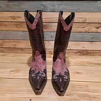 Front view of pink and brown cowboy boots standing upright