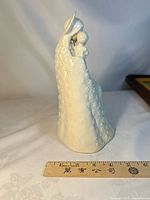 Left side view showing Madonna holding Child and robe texture with ruler for scale