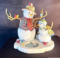 Front view of Lenox snowman figurine showing grandpa and child snowmen, birds, and ice hole