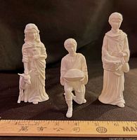 Three Lenox Children of Bethlehem figurines displayed with ruler for scale