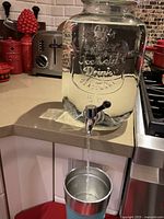 Dispenser on counter in use, showing spigot flow