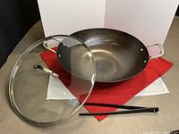 Wok, glass lid, and kitchen tweezers group view