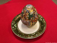 Cloisonné egg displayed on porcelain plate