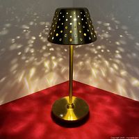 Front view of gold LED table lamp illuminated