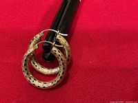 Front view of both 14K gold hoop earrings showing dotted pattern and latch closures