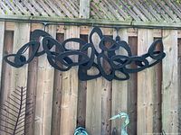 Full view of sculpture hung horizontally on fence
