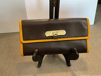 Front view showing leather, gold bar clasp, yellow trim