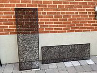 Both metal panels upright against brick wall showing size and design