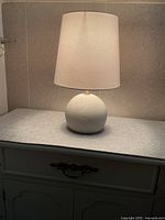 Full view of lamp on cabinet, showing base and shade