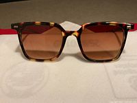 Front view showing frame shape, lens tint, and tortoiseshell pattern