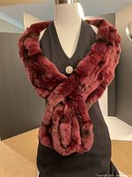 Dress displayed with burgundy fur wrap draped over shoulders