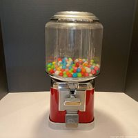 Front view of Beaver red gumball machine with gumballs inside
