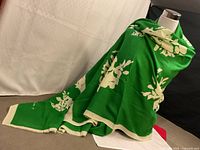 Scarf draped on mannequin showing full size, green with cream pattern