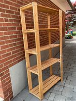 Full view of wooden rack against brick wall