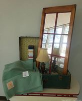 All items grouped: open trunk, blanket, mirror, lamp, tin visible