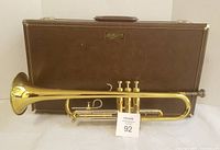 Trumpet standing in front of brown Getzen hard case
