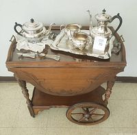 Tea cart with silver service arranged on top