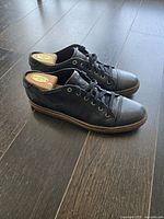 Side view of the black leather Frye sneakers showing the outer side profile with visible textured leather and sole condition.