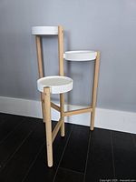 Side view showing all three tiers and wooden legs with white metal platforms.