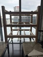 Front view of the wooden wine rack showing three rows with horizontal bars to hold bottles