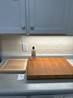 Image showing both cutting boards side-by-side on countertop with Howard mineral oil bottle between them.