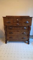 Full front view of oak dresser showing all seven drawers and bracket feet