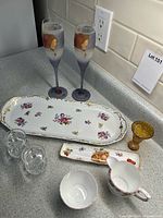 Photo showing all 9 pieces on kitchen countertop including stem glasses, trays, creamer, sugar bowl, amber vase, and salt/pepper shakers