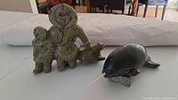 Front view showing both Inuit family carving and narwhal sculpture on table