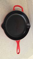 Top view of the red enameled cast iron Dutch oven showing smooth black interior and spout on side.