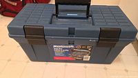 Closed Mastercraft blue plastic tool box with black handle and latches, showing product label on front.