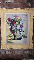 Full view of framed oil painting depicting colorful floral bouquet in vase and bowl