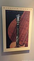 Front view of the William Laskin musician poster showing guitar neck with engraved inlays and wood grain background.