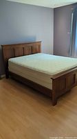 Assembled queen bed frame with mattress and box spring angled left
