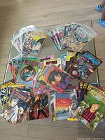 Overhead photo showing a large spread of comic books laid out on the floor, multiple titles visible including Robotech, Shuriken, Captain Harlock.