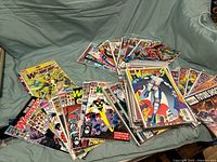 Large assortment of Marvel The Warriors comic books arranged in groups on a cloth.