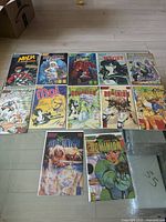 Full shot of all 12 comics laid out in three rows on the floor, shows titles and cover art clearly