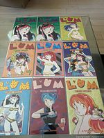 Top view of all 8 Lum Urusei Yatsura manga comics laid out on table, showing front covers with colorful character illustrations.