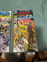 Photo showing the first half of the Cage comic series with vibrant action cover artwork, issues 1-10.