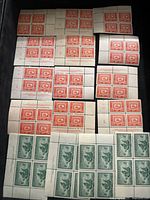 Full view of the red 15-cent stamps and green 4-cent stamps, shown in multiple blocks and strips with margins and perforations.