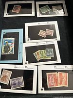 Multiple unused Chinese postage stamps on black album pages with white Borders with catalog and price sections.