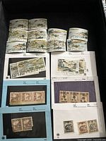 Photo of multiple Chinese stamps arranged on black and blue album pages showing different values and designs including buildings, landscapes, and Chinese characters.