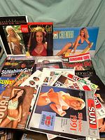 Collection of vintage Sunshine Girl calendars with covers visible from 1991, 1998, 1999, and 2000, featuring models in swimwear.