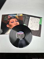 Vinyl record, album cover with Andy Warhol pop art style portrait of Aretha Franklin, and inner sleeve with line art portrait and printed lyrics.
