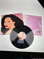 Vinyl record with stylized portrait cover art of Diana Ross by Andy Warhol, along with the inner sleeve showing engraved serial number.