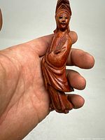 Front view of the boxwood Guanyin carving held in hand showing detailed facial features and robes.