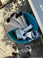 Photo of multiple rolled posters in a blue container showing their condition and storage.