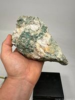 Front side view of the Fuchsite specimen showing green and white crystalline areas with some rough texture.