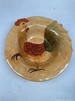 Top-down view of the large round ceramic plate showing detailed rooster in the center.