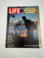 Front cover of Life magazine December 1961 special issue titled 'Our Splendid Outdoors' showing two people by a fire outdoors with mountainous background.
