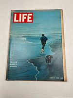 Front cover showing Senator Robert F Kennedy walking along shore with a dog, featuring magazine title and date.